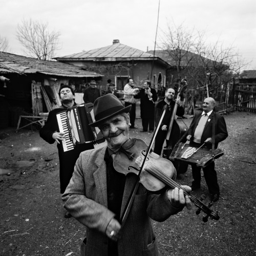 ルーマニアのクレジャニ村で、〇〇年一二月二六日に撮影したタラフ・ドゥ・ハイドゥークス。一番前でヴァイオリンを弾いているのは、今は亡きニコラエ爺さん。〈独裁者のバラード（Balada Conducatorolui）〉という曲で「（チャウシェスクが失脚した八九年一二月）二二日という日に生きた時間が戻ってきた」と歌った。